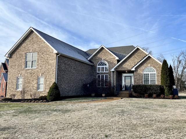 view of front of home with a front yard and brick siding