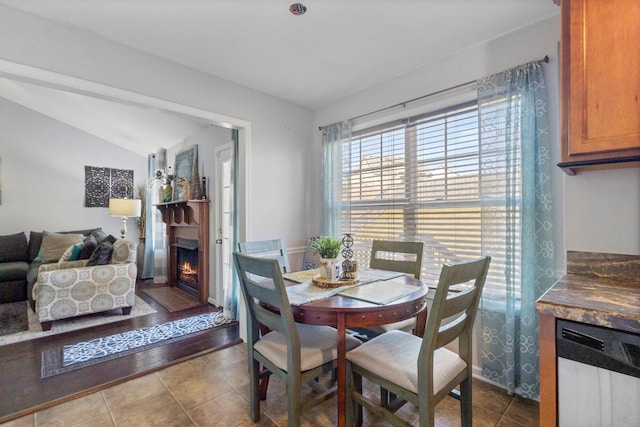 dining space featuring vaulted ceiling and tile patterned floors