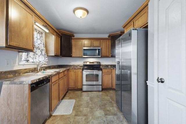 kitchen with tile patterned flooring, appliances with stainless steel finishes, and sink