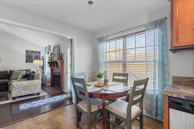 dining room featuring tile patterned flooring and lofted ceiling