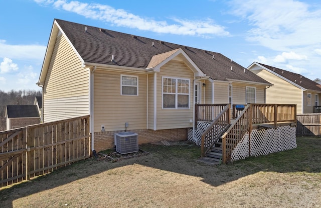 rear view of property with cooling unit, a yard, and a deck