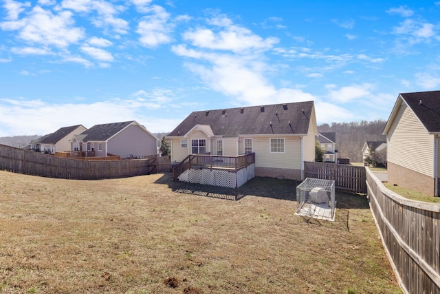 back of house featuring a deck and a lawn