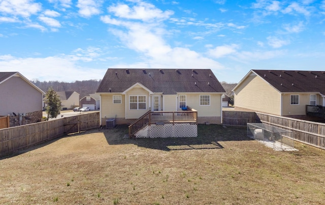 rear view of property featuring central AC unit, a yard, and a deck