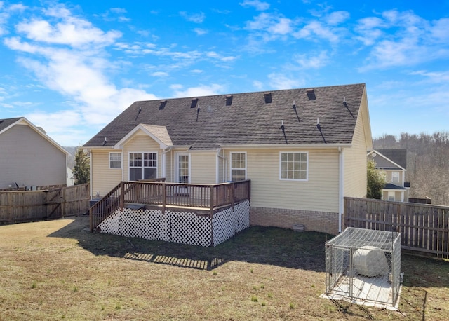 rear view of property featuring a yard and a deck