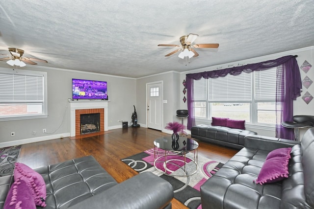 living room featuring a brick fireplace, crown molding, and dark wood-type flooring