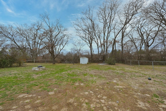 view of yard featuring a fire pit and a storage unit