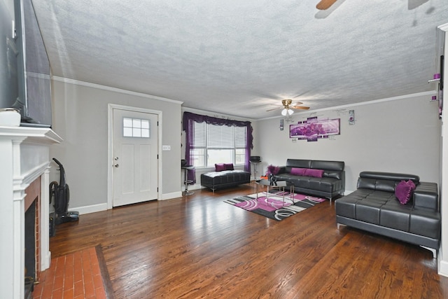 living room featuring ceiling fan, ornamental molding, dark hardwood / wood-style floors, and a textured ceiling