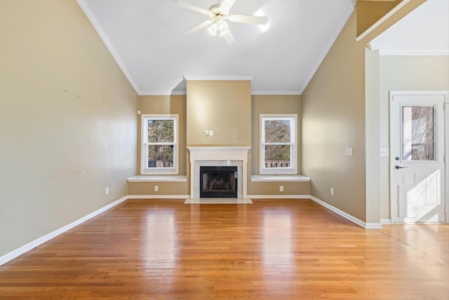 unfurnished living room with a high end fireplace, lofted ceiling, ceiling fan, light hardwood / wood-style floors, and ornamental molding