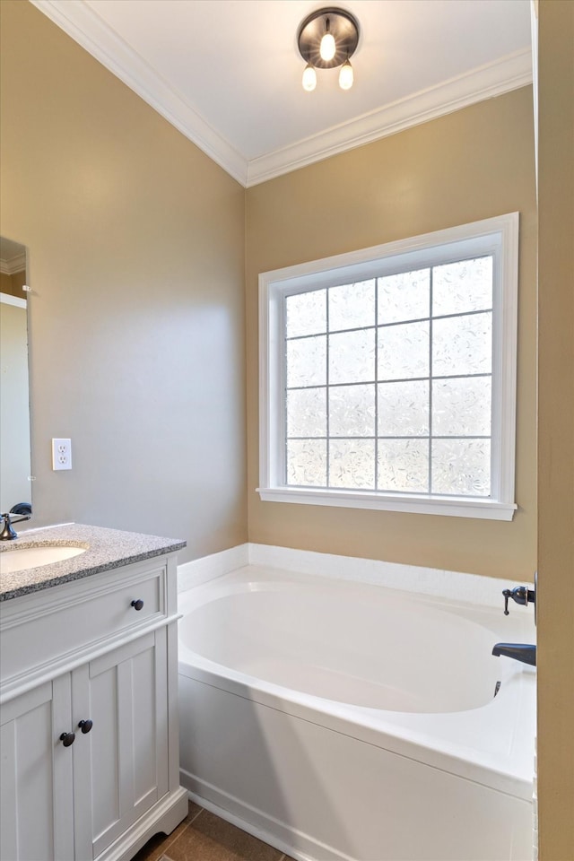 bathroom with a bath, a healthy amount of sunlight, vanity, and ornamental molding