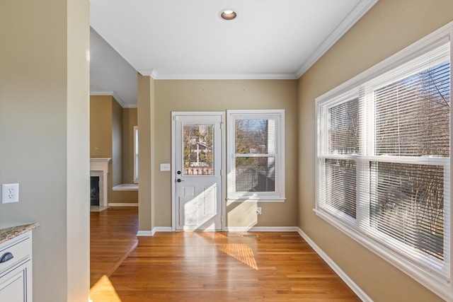 doorway with ornamental molding and light hardwood / wood-style flooring