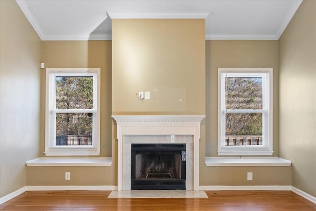 unfurnished living room featuring hardwood / wood-style floors, crown molding, and a healthy amount of sunlight