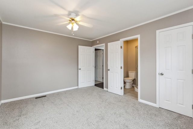 unfurnished bedroom with ornamental molding, carpet flooring, ceiling fan, and ensuite bath