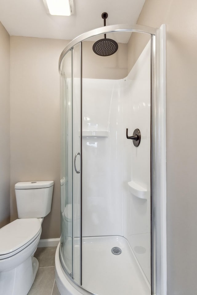 bathroom with tile patterned flooring, toilet, and walk in shower