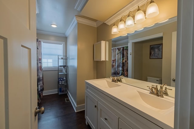 bathroom featuring hardwood / wood-style flooring, ornamental molding, toilet, and vanity