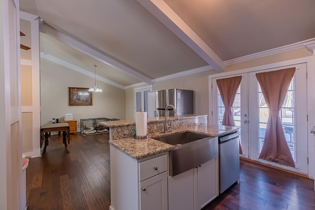 kitchen with sink, light stone counters, decorative light fixtures, appliances with stainless steel finishes, and white cabinets