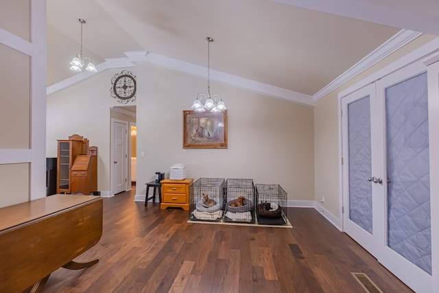 interior space featuring dark hardwood / wood-style floors, lofted ceiling, ornamental molding, an inviting chandelier, and french doors