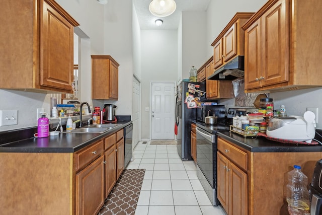 kitchen featuring appliances with stainless steel finishes, sink, a high ceiling, and light tile patterned floors