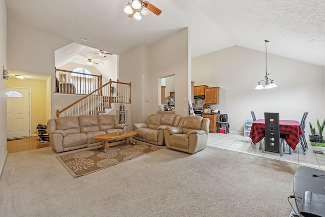 carpeted living room featuring high vaulted ceiling, ceiling fan with notable chandelier, and a textured ceiling