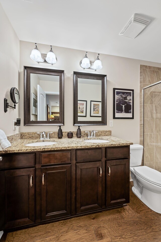 bathroom featuring vanity, a shower, and toilet