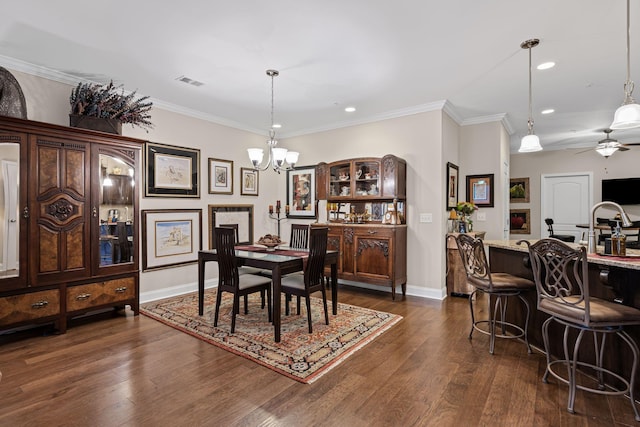 dining space featuring crown molding, dark hardwood / wood-style floors, and ceiling fan with notable chandelier