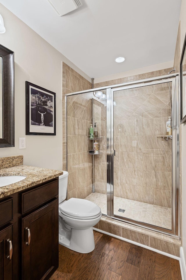 bathroom with vanity, hardwood / wood-style floors, walk in shower, and toilet