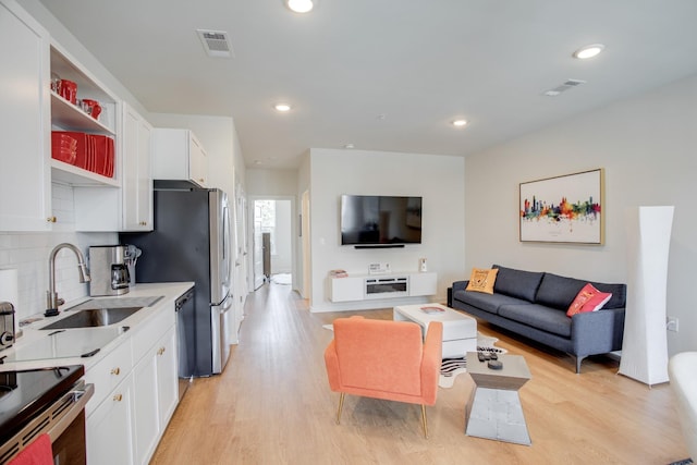 living room featuring sink and light wood-type flooring