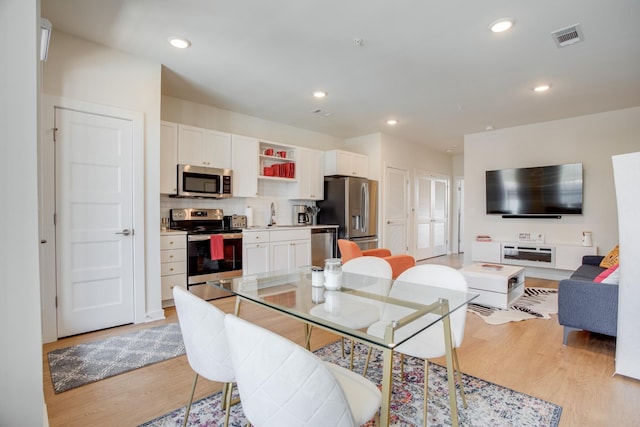 dining room with sink and light wood-type flooring