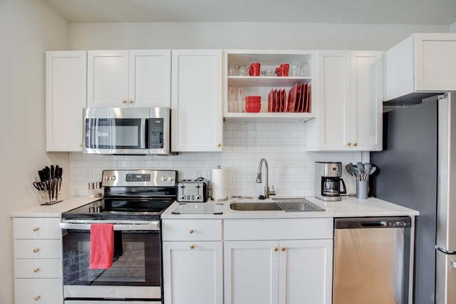 kitchen with white cabinetry, appliances with stainless steel finishes, sink, and backsplash