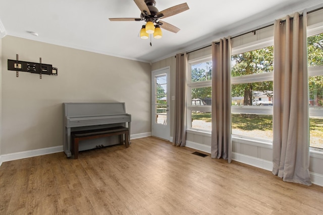 misc room with ornamental molding, plenty of natural light, ceiling fan, and light hardwood / wood-style flooring