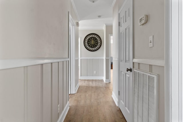 hallway featuring wood-type flooring and ornamental molding