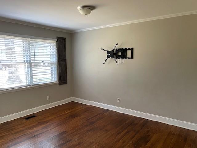 unfurnished room featuring crown molding and dark hardwood / wood-style floors