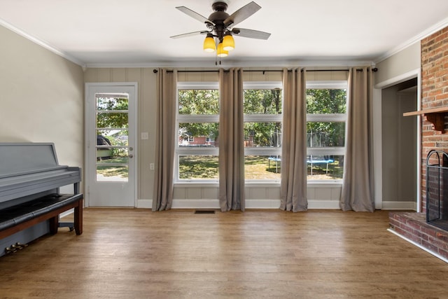 living room with hardwood / wood-style flooring, a fireplace, and ornamental molding