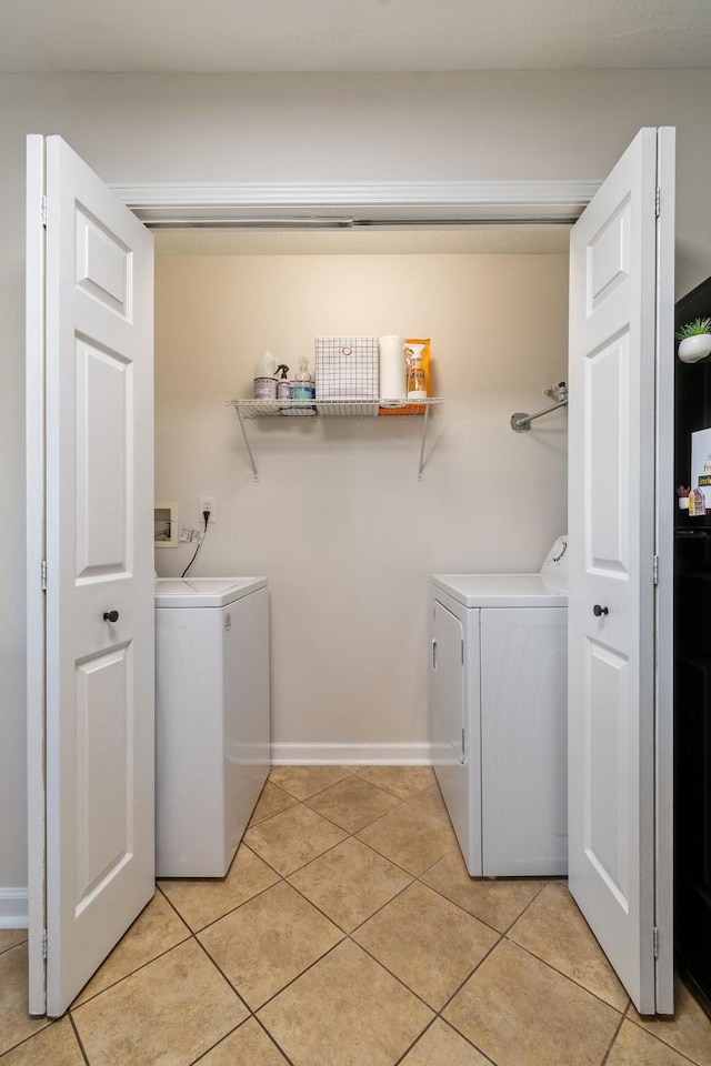 washroom with washer and dryer and light tile patterned flooring