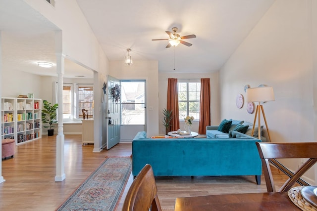 living room with a wealth of natural light, vaulted ceiling, and decorative columns