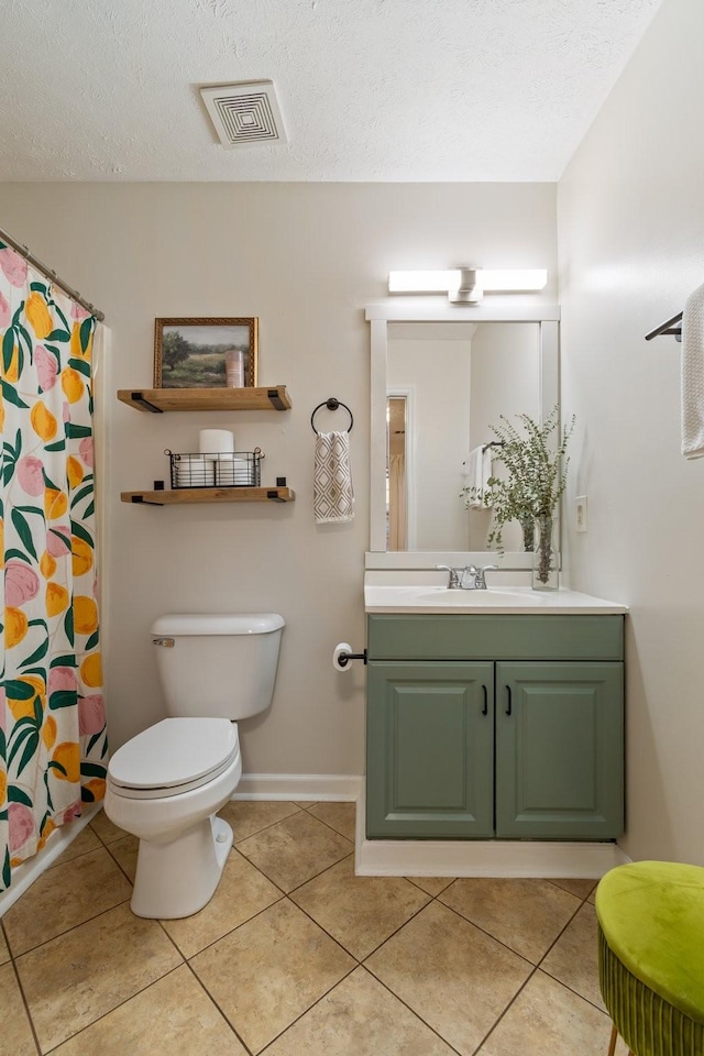 bathroom with vanity, a textured ceiling, tile patterned floors, and toilet