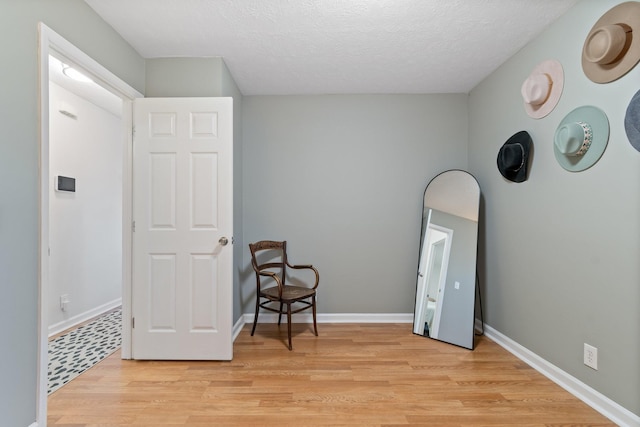 sitting room featuring light hardwood / wood-style flooring and a textured ceiling