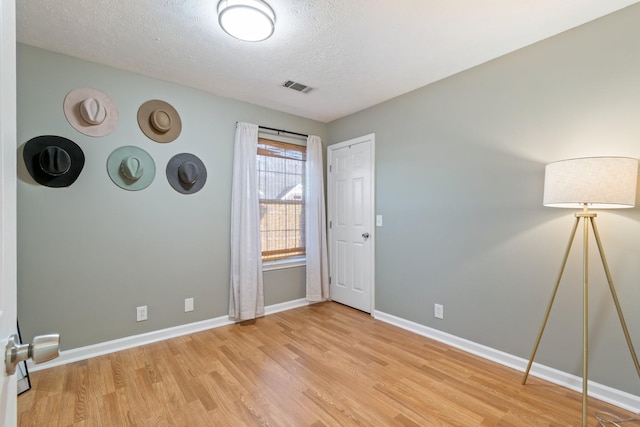 empty room featuring light hardwood / wood-style flooring and a textured ceiling