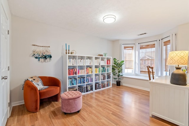 sitting room with hardwood / wood-style floors and a textured ceiling