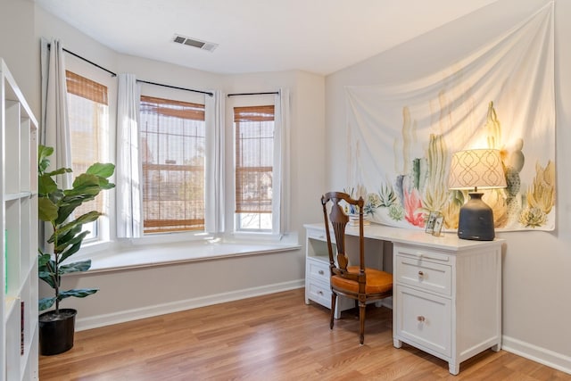 office featuring built in desk and light hardwood / wood-style floors