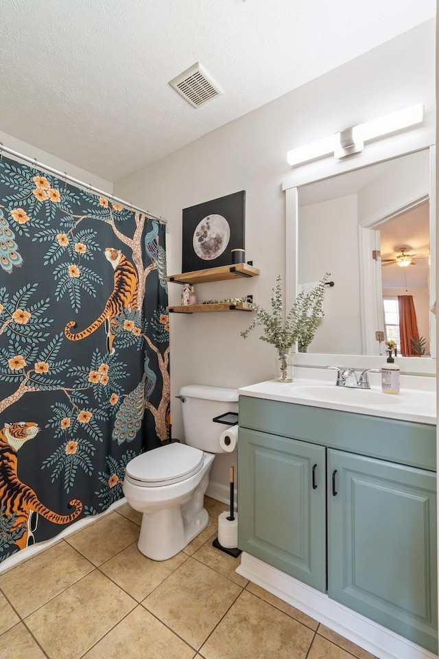 bathroom with vanity, a textured ceiling, tile patterned floors, and toilet