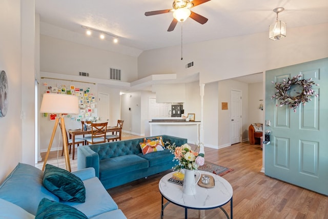 living room featuring high vaulted ceiling, hardwood / wood-style floors, and ceiling fan