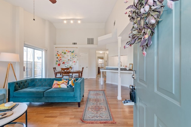 living room with a high ceiling and light wood-type flooring