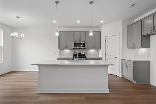 kitchen with gray cabinetry, sink, pendant lighting, and stainless steel appliances