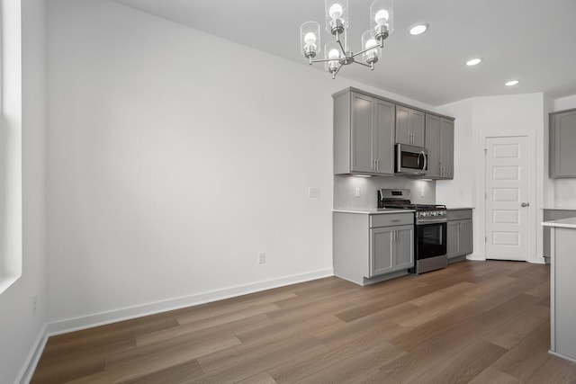 kitchen with gray cabinets, appliances with stainless steel finishes, and pendant lighting