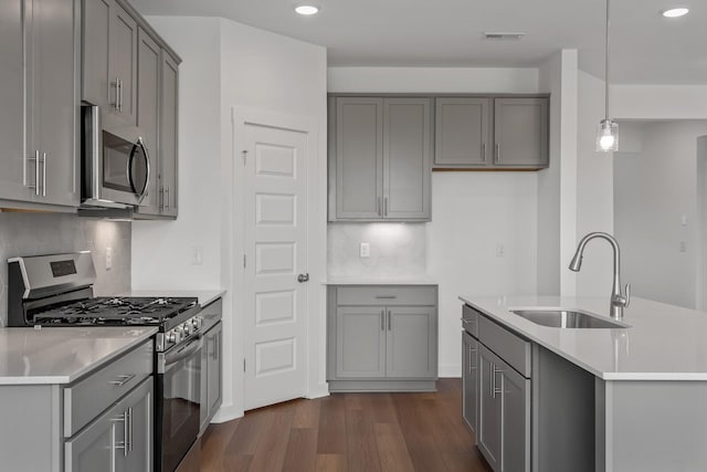 kitchen featuring gray cabinets, appliances with stainless steel finishes, sink, and decorative light fixtures