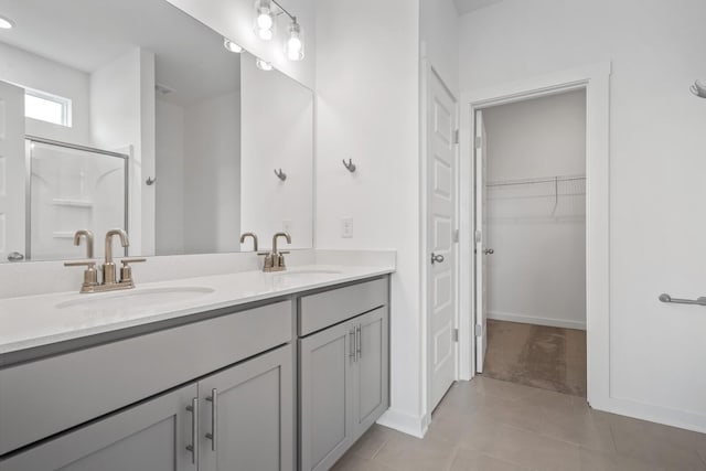 bathroom with an enclosed shower, vanity, and tile patterned floors