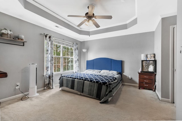 carpeted bedroom with crown molding, a raised ceiling, and ceiling fan