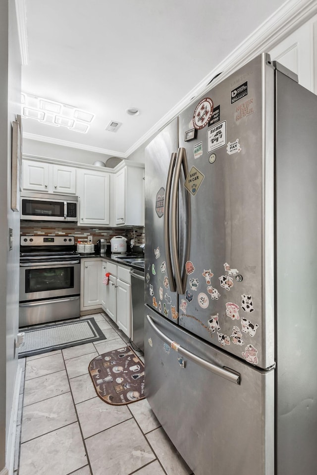 kitchen featuring crown molding, stainless steel appliances, decorative backsplash, and white cabinets