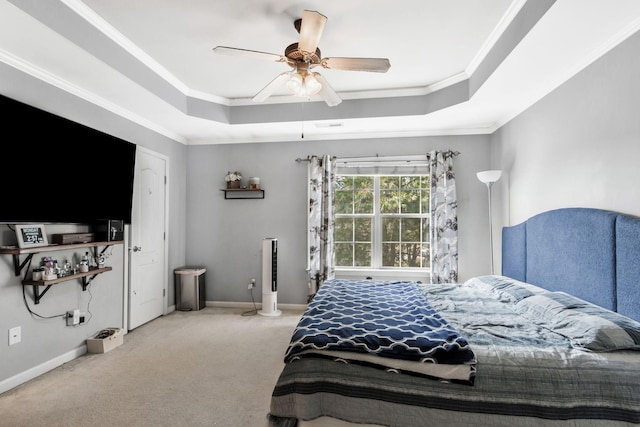 bedroom with ceiling fan, light colored carpet, ornamental molding, and a tray ceiling