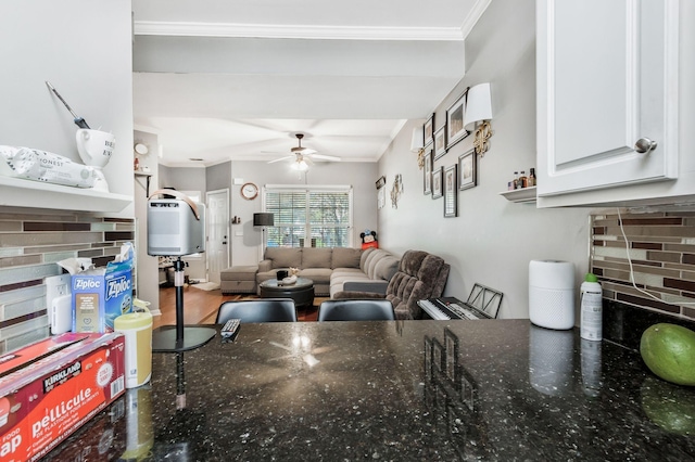 kitchen with white cabinetry, crown molding, tasteful backsplash, hardwood / wood-style flooring, and ceiling fan